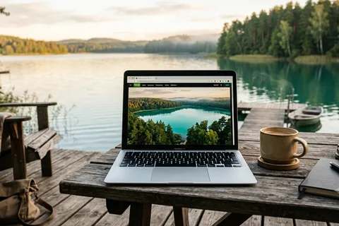 Laptop na pomoście z widokiem na turkusowe jezioro